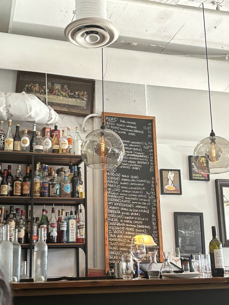 The bar with wine bottles and the chalkboard menu